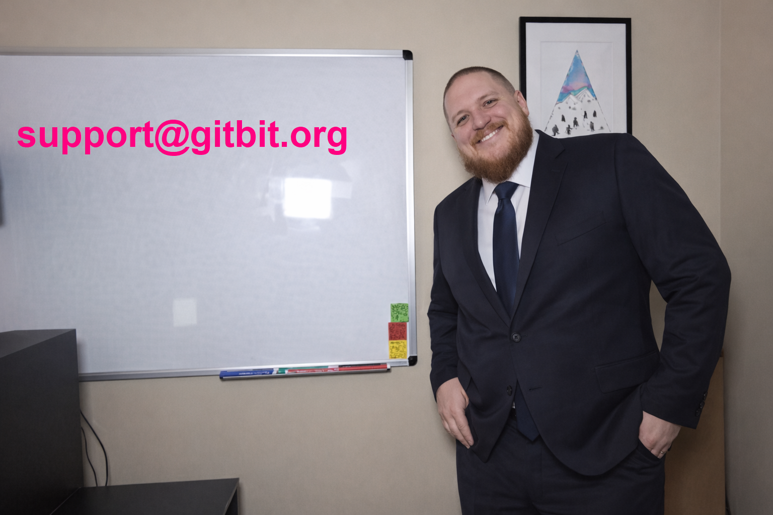 John Gruber, founder of Gitbit, standing next to a whiteboard that reads support@gitbit.org